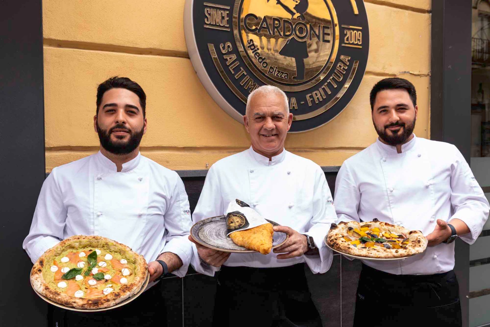 La famiglia Cardone davanti alla pizzeria con le pizze