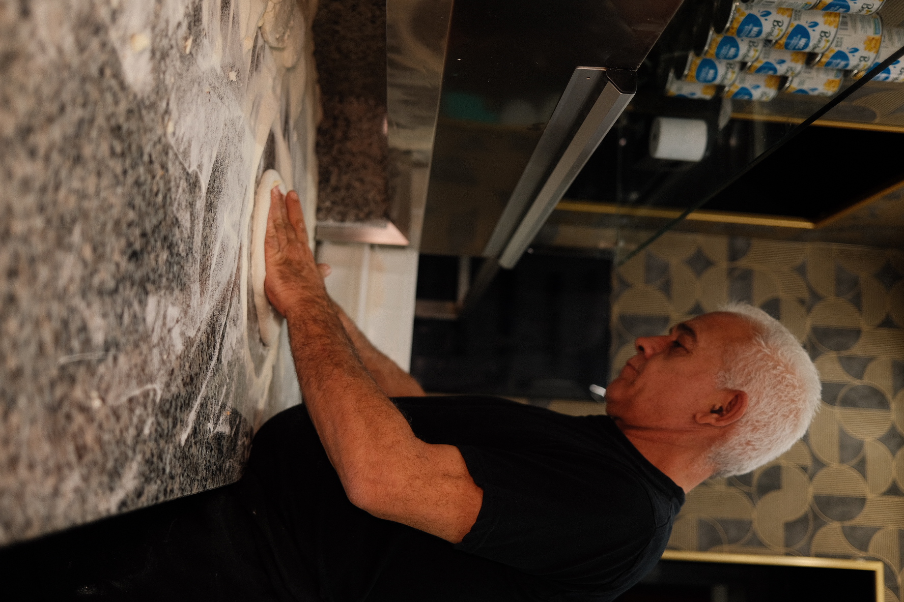 Un pizzaiolo lavora l'impasto a mano